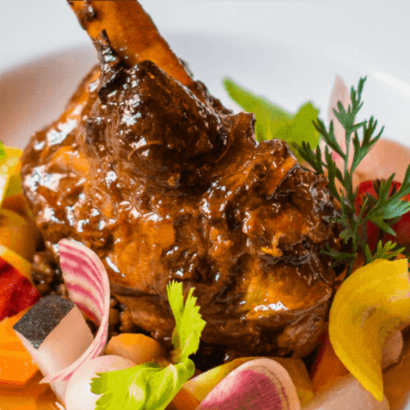 Une charmante cuisine de style provençal avec un mur d'accent rouge brique et des éléments en bois clair, évoquant la convivialité française